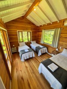 una camera con tre letti in una cabina di legno di Quinta Terra Sagrada a Urubici