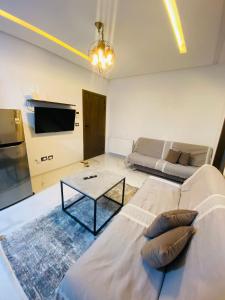 een woonkamer met een bank en een tafel bij Dar awina in Bin Rhilouf