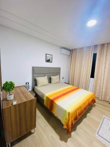 een slaapkamer met een bed en een ladekast bij Dar awina in Bin Rhilouf