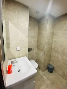 een badkamer met een witte wastafel en een toilet bij Dar awina in Bin Rhilouf +1 foto