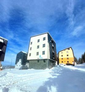 ein großes weißes Gebäude im Schnee mit Gebäuden in der Unterkunft Bianca in Jahorina
