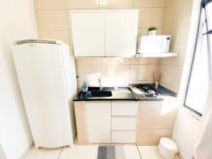 a small kitchen with a sink and a refrigerator at Ap8 - Aconchegante e Completo com Ótimo Custo-Benefício in Guaíra