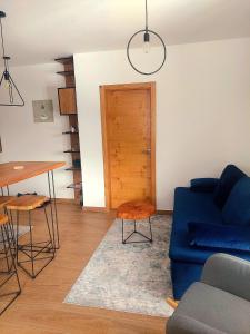 ein Wohnzimmer mit einem blauen Sofa und einem Tisch in der Unterkunft Bianca in Jahorina + 3 Fotos