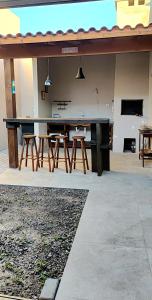 a patio with a large table and some chairs at Casa de Benê in Tramandaí