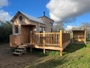 a large wooden house with a deck and a building at Tiny House chez Annette in Darvoy