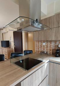 una cucina con piano di lavoro in vetro e fornello di Elia Sunset a Lagomandra