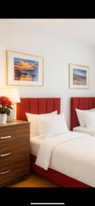 two beds in a bedroom with a red headboard at Apartament Diana - Traugutta Wrocław in Wrocław