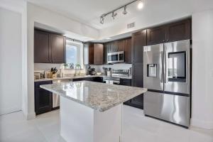 uma cozinha com electrodomésticos de aço inoxidável e armários castanhos em RIVER FLY IN The Cocoa Island Horizon View RFI-714 em Audubon