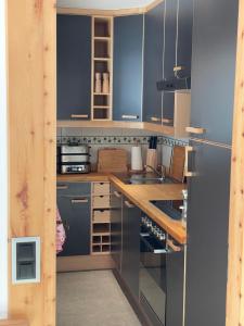a kitchen with stainless steel appliances and wooden cabinets at 2,5 Zimmer Wohnung mit Bergblick in Engadin in Zuoz