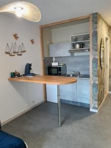 a kitchen with a wooden table and a sink at Chez Fany et Ben in Cabourg