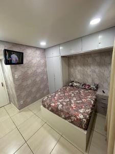 Un dormitorio con una cama y un televisor en una pared. en Hostel San Pietro, en Santos