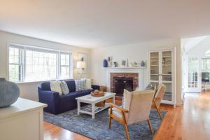 Una sala de estar con un sofá azul y una chimenea. en 5-Mins to Forest Beach Dog Friendly, en Chatham