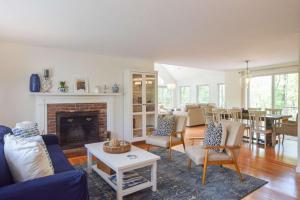 Una sala de estar con un sofá azul y una chimenea. en 5-Mins to Forest Beach Dog Friendly, en Chatham