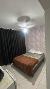 Un dormitorio con una cama y una cortina negra en Hostel San Pietro, en Santos 1 foto más