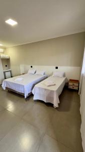 due letti uno accanto all'altro in una stanza di Hotel Tamboril a Barra Bonita