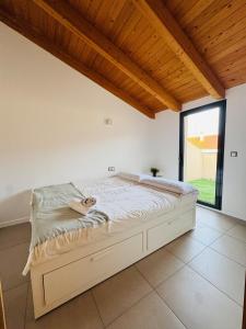 uma cama num quarto com uma grande janela em El Sueño De Albarracín II Duplex em Albarracín