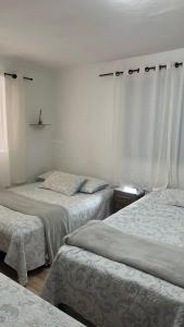 a bedroom with three beds and a window at Chácara das Suculentas in Mairiporã +16 photos