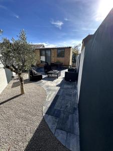 eine Terrasse mit einem Baum und einem Gebäude in der Unterkunft Tiny house 3 à 4 personnes in Saint-Loup-Nantouard