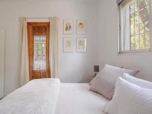 a bedroom with a white bed and a window at 5-Bedroom Villa with Pool, Swimjet and Jacuzzi in Comares +31 photos