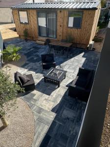 eine Terrasse mit Stühlen, einem Tisch und einem Haus in der Unterkunft Tiny house 3 à 4 personnes in Saint-Loup-Nantouard + 30 Fotos