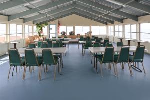 a large room with tables and green chairs at Edgewater Inn and Suites in Pismo Beach