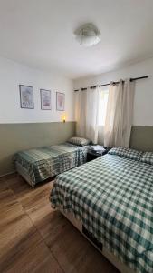 a bedroom with two beds and a window at Chácara das Suculentas in Mairiporã