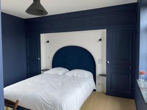 a bedroom with a large bed with a blue headboard at La Parcelle in Lezennes