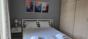 a bedroom with a white bed with two pillows at Parastaseis City Apartment Central in Patra