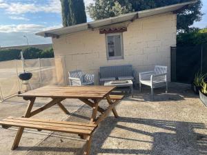 una mesa de picnic y sillas frente a una casa en Gite indépendant dans propriété sécurisée avec piscine, en Servian