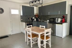eine Küche mit einem Tisch und Stühlen darin in der Unterkunft SERENITY Gite indépendant dans propriété avec piscine in Servian