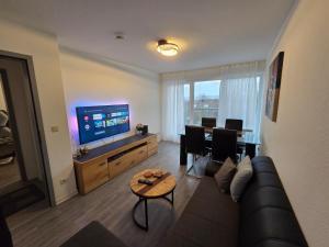 ein Wohnzimmer mit einer Couch und einem Tisch und einem Fernseher in der Unterkunft 3-room apartment with balcony in Northeim