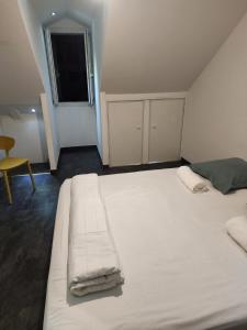 サン・ドニにあるDuplex T3 centre-villeの椅子付きの客室内の大きな白いベッド