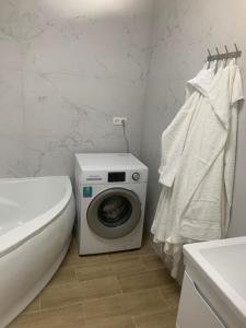 a bathroom with a washing machine and a toilet at Будинок з чаном in Druzhba