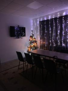 a christmas tree in a room with a table and chairs at Будинок з чаном in Druzhba +4 photos