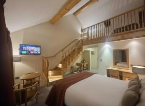 The Terrace Hotel في ماغيرافيلت: غرفة نوم بها سرير كبير ودرج