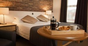 a hotel room with a bed and a table with a tray of bread at The Terrace Hotel in Magherafelt
