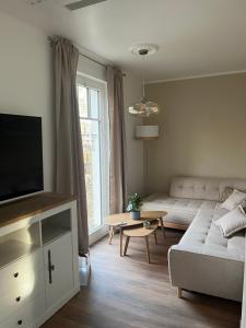 a living room with a couch and a tv at Haus Maria am Meer in Göhren