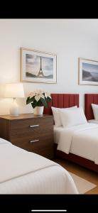 a bedroom with two beds and a vase with a flower at Apartament Diana - Traugutta Wrocław in Wrocław