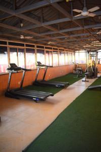 a gym with several treadmills and green mats at Canalta Hotel Restaurant Bar in Jaipur