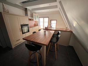 a kitchen with a wooden table and some chairs at Sand & Chill - Appartement 65R in Rouffach