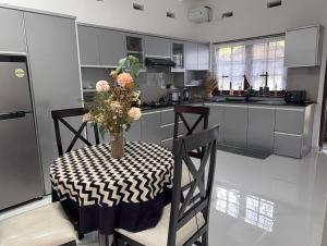 a kitchen with a table with a vase of flowers on it at Rumanga Residence in Angoda