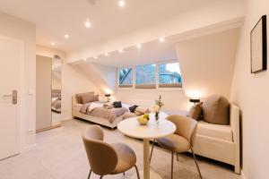 a living room with a bed and a table and chairs at saGo Airporthouse in Düsseldorf