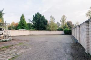 an empty parking lot next to a brick wall at saGo Airporthouse in Düsseldorf
