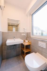 a bathroom with a sink and a toilet at saGo Airporthouse in Düsseldorf +91 photos
