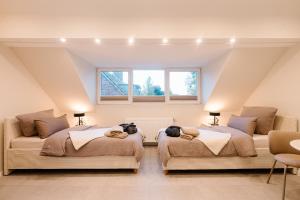 a attic room with two beds and a window at saGo Airporthouse in Düsseldorf