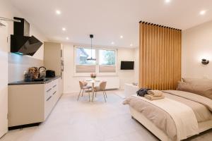 a bedroom with a bed and a kitchen and a table at saGo Airporthouse in Düsseldorf