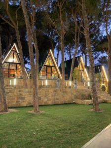 a house with a stone wall and trees at night at Pine Straw Douma in Douma