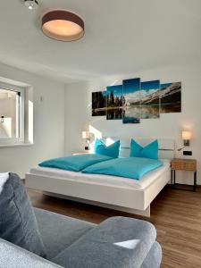 a bedroom with a large bed with blue pillows at MOUNTAIN HOME apartment in Finkenberg +8 photos