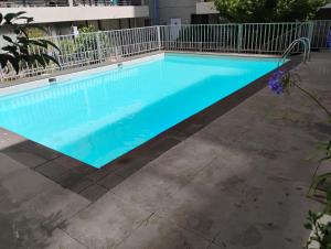 uma piscina com água azul em frente a um edifício em Amplio departamento viña centro em Viña del Mar mais 1 fotografia