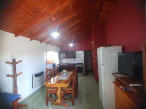 Una cocina con una mesa de madera y un refrigerador. en cabaña refugio junto al cerro, en San Luis